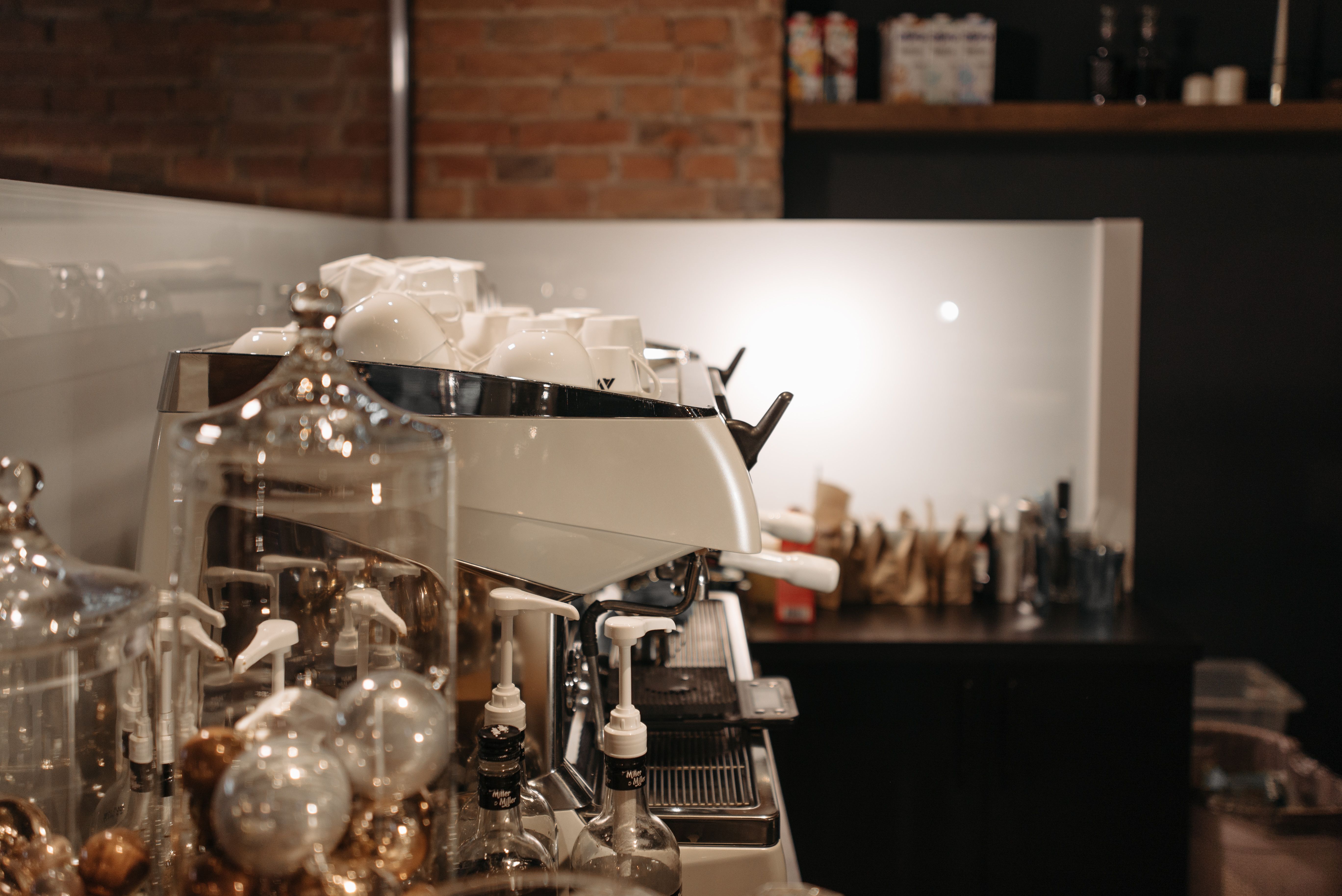 Mesa de cafetería porteña con café con leche, medialunas y notebook en un local de Palermo
