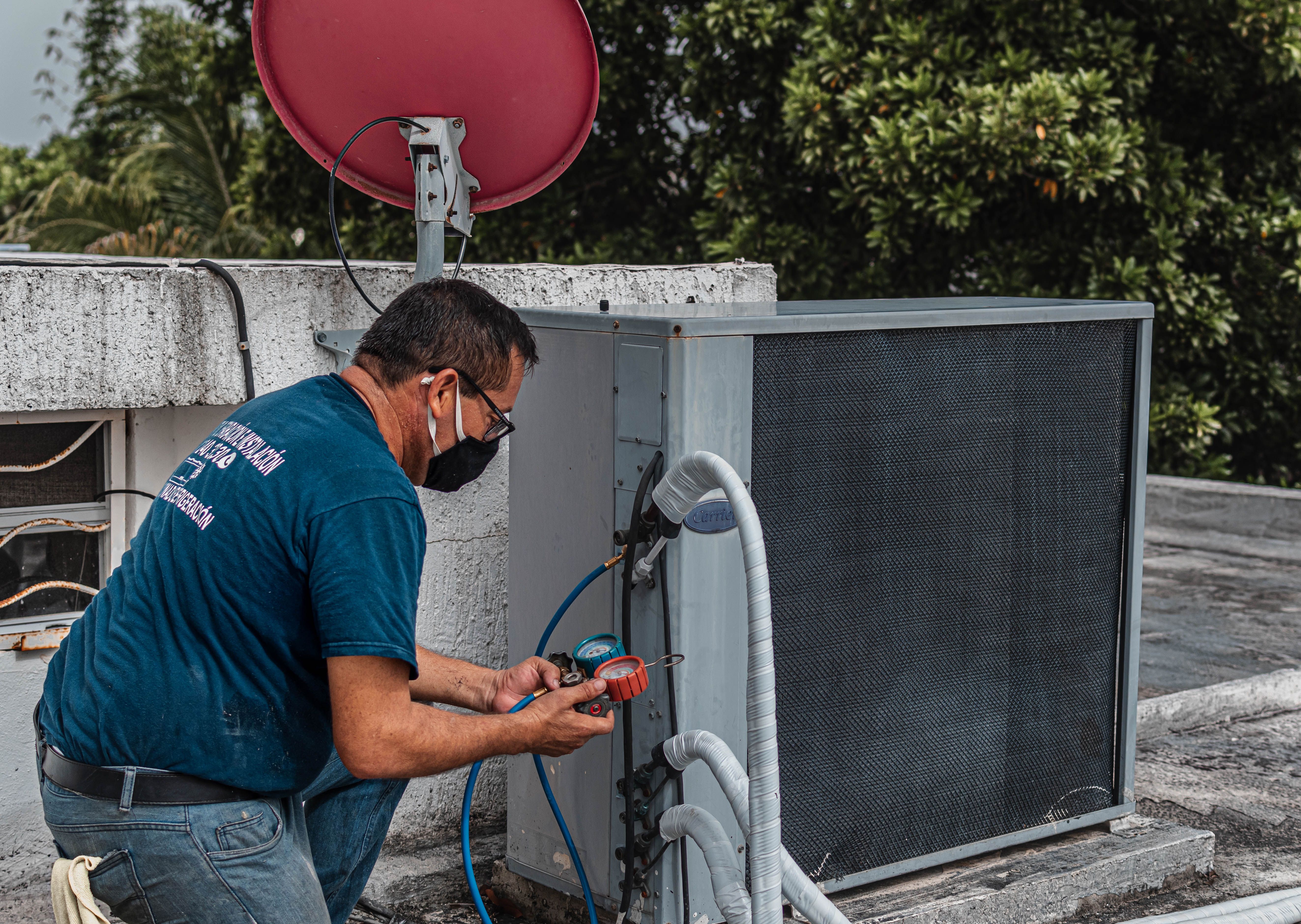 Técnico haciendo el service y la limpieza de una unidad de aire acondicionado en Buenos Aires