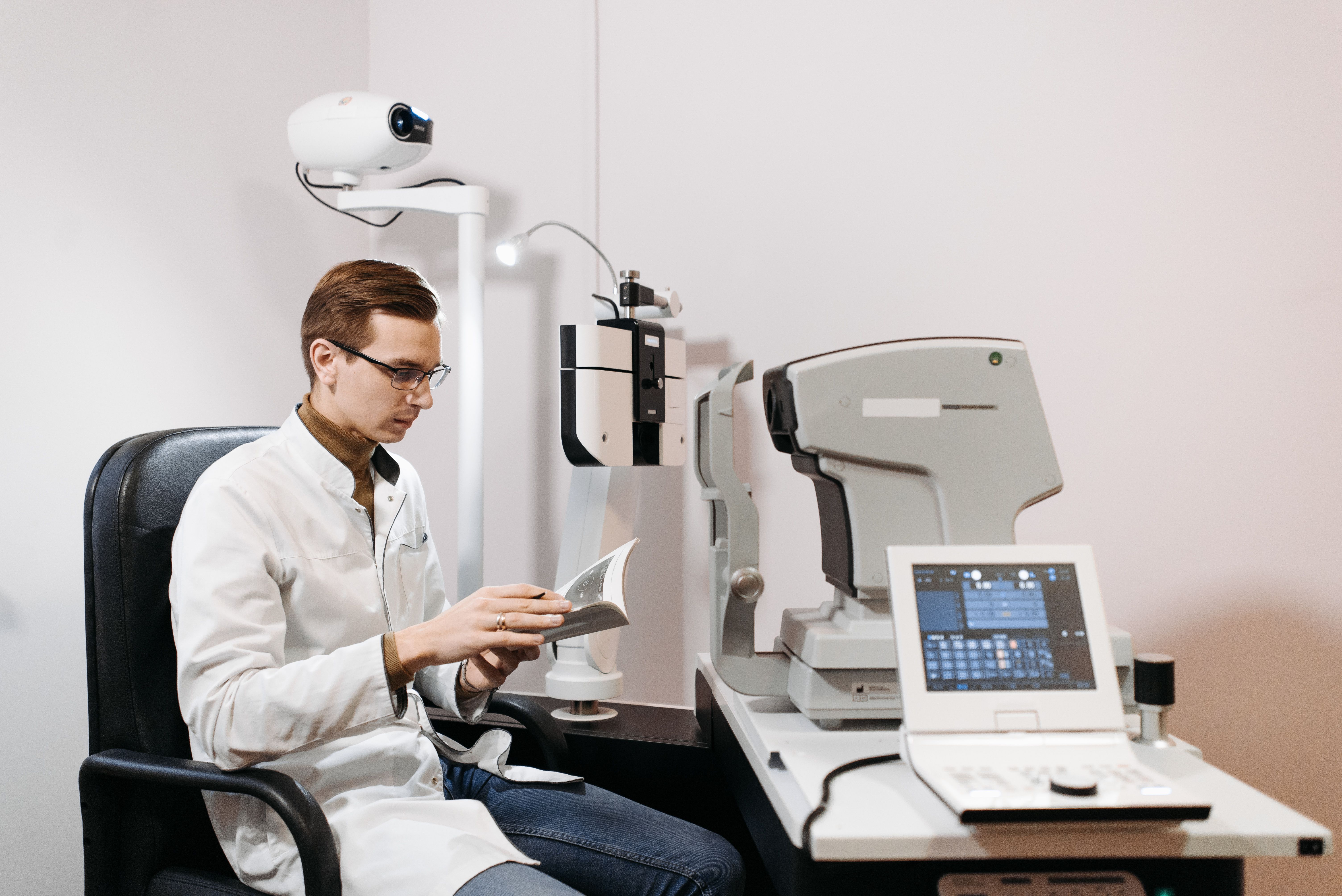 Equipo médico oftalmológico operando con microscopio quirúrgico en un quirófano moderno de una clínica de ojos de Buenos Aires