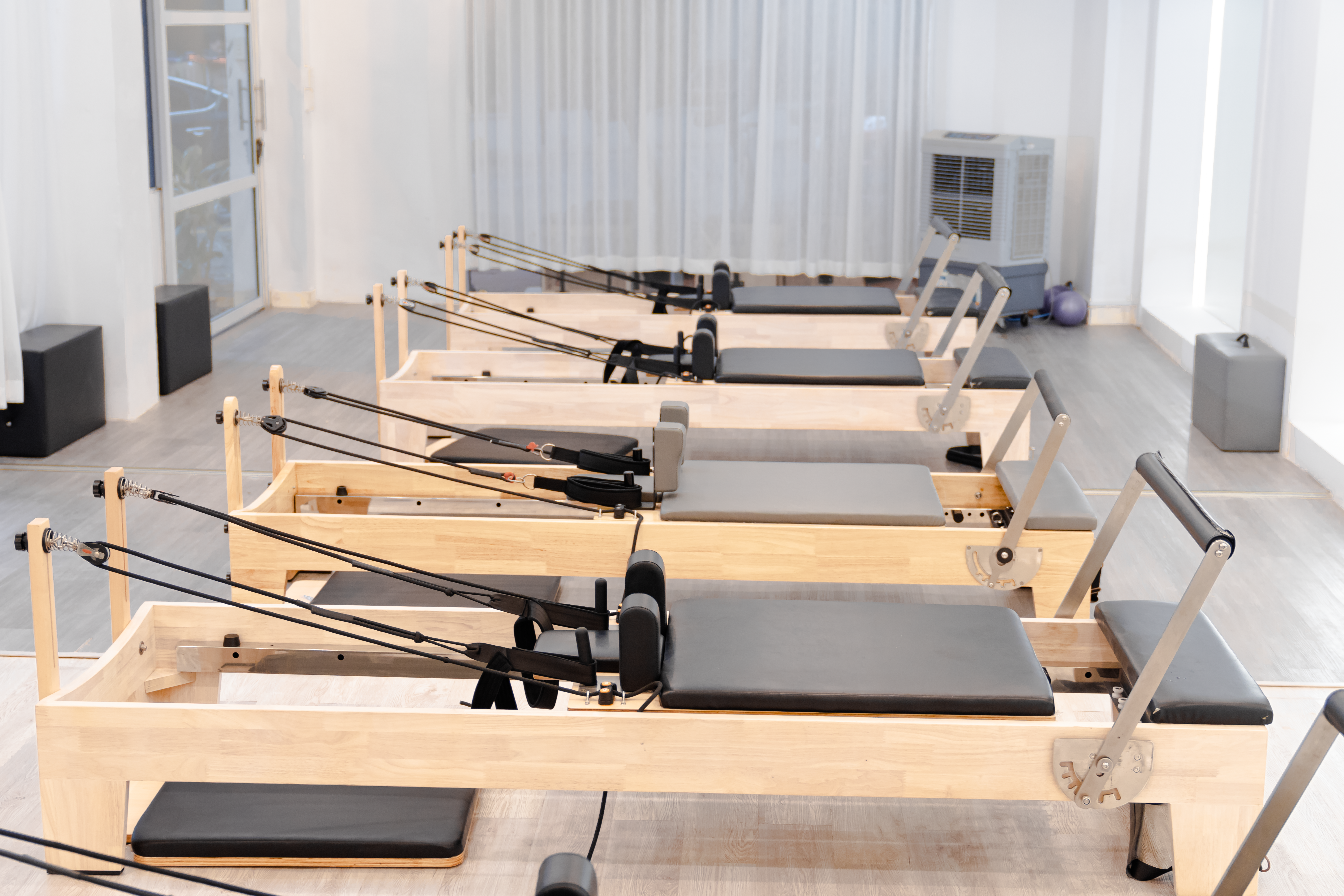 Sala de un estudio de pilates de Buenos Aires con varias camas reformer alineadas y buena iluminación