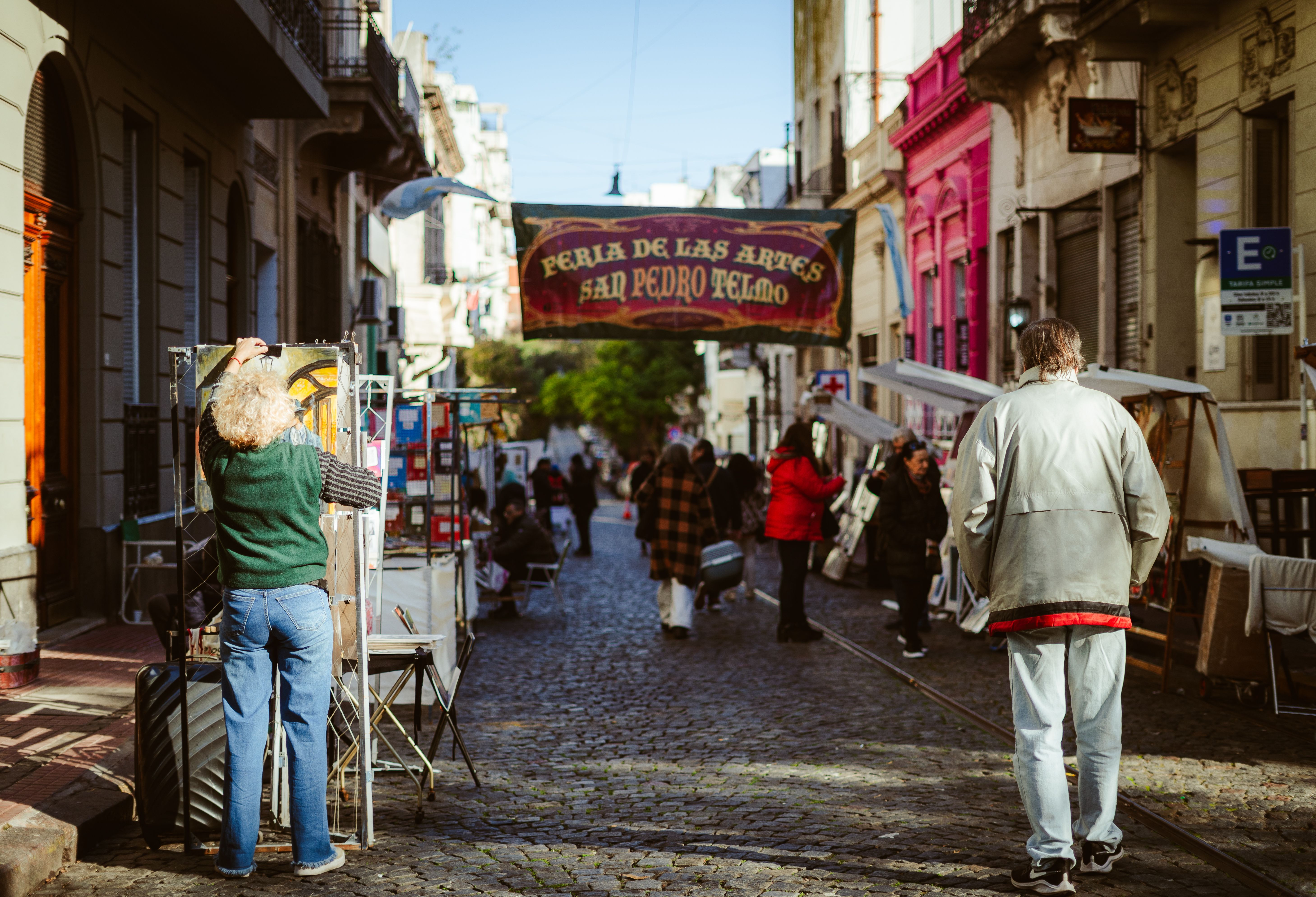 Calle empedrada del casco histórico de San Telmo, Buenos Aires, con fachadas antiguas y turistas